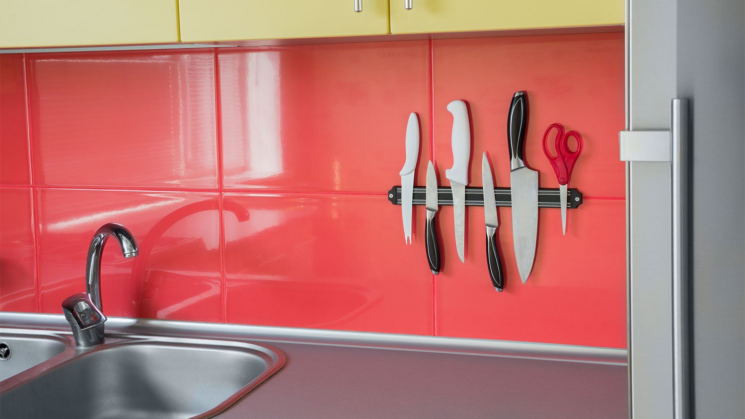 A view of a kitchen with a magnetic knife strip