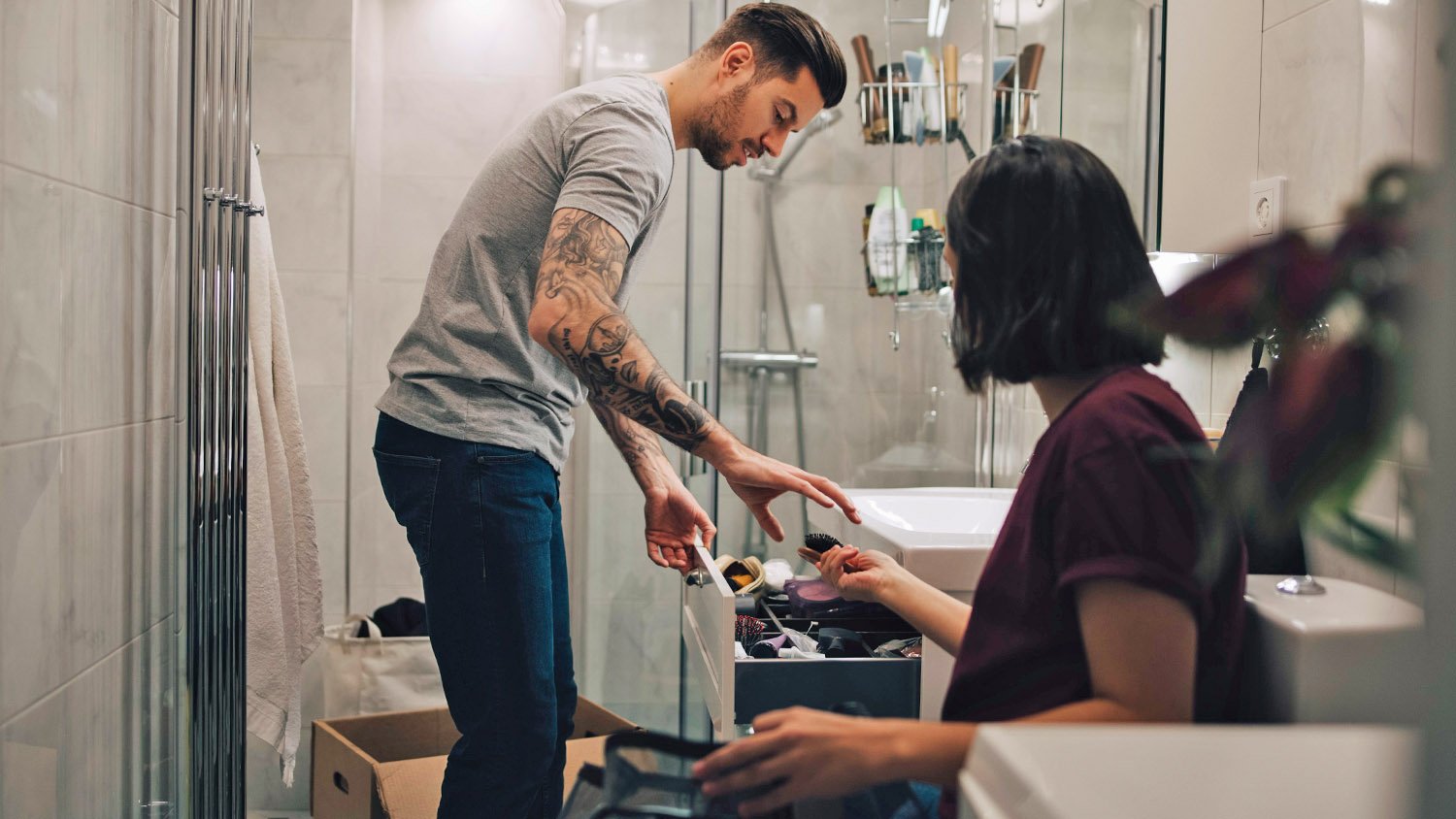 couple boxing up items in bathroom