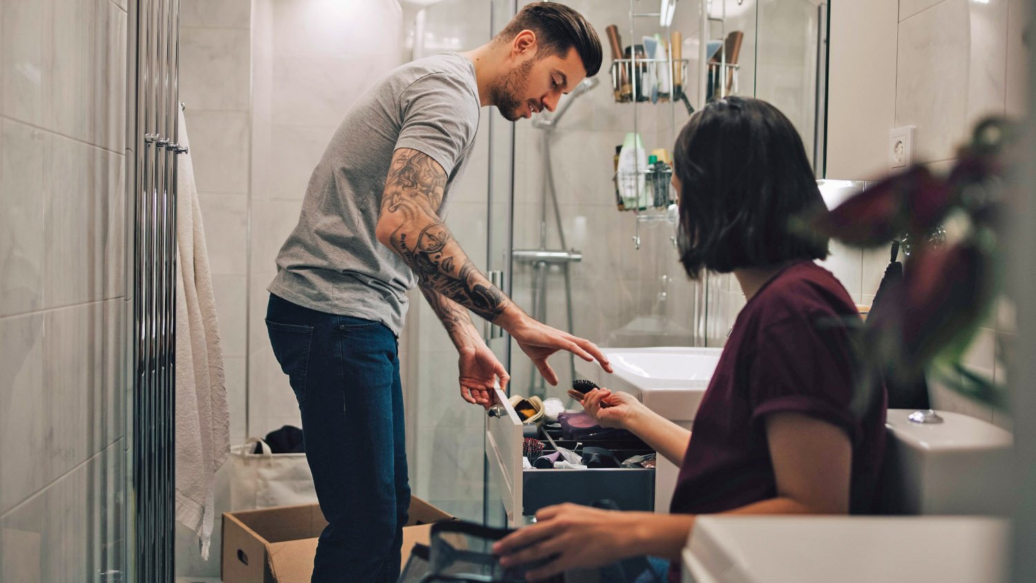 couple boxing up items in bathroom  