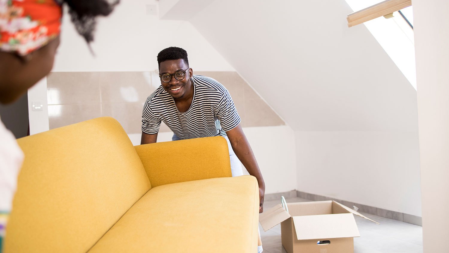 Couple carrying yellow sofa