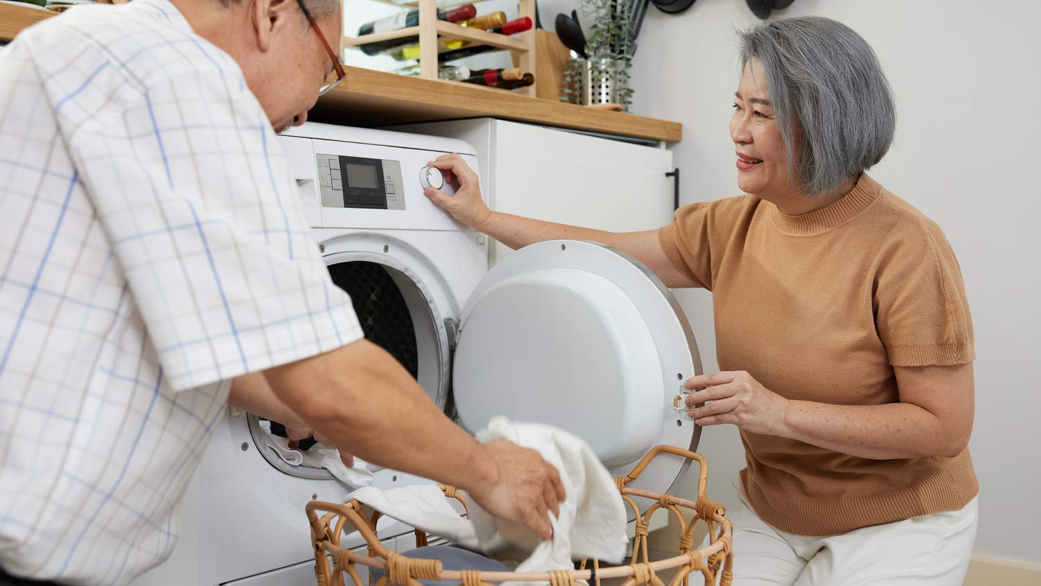 elderly couple doing laundry together