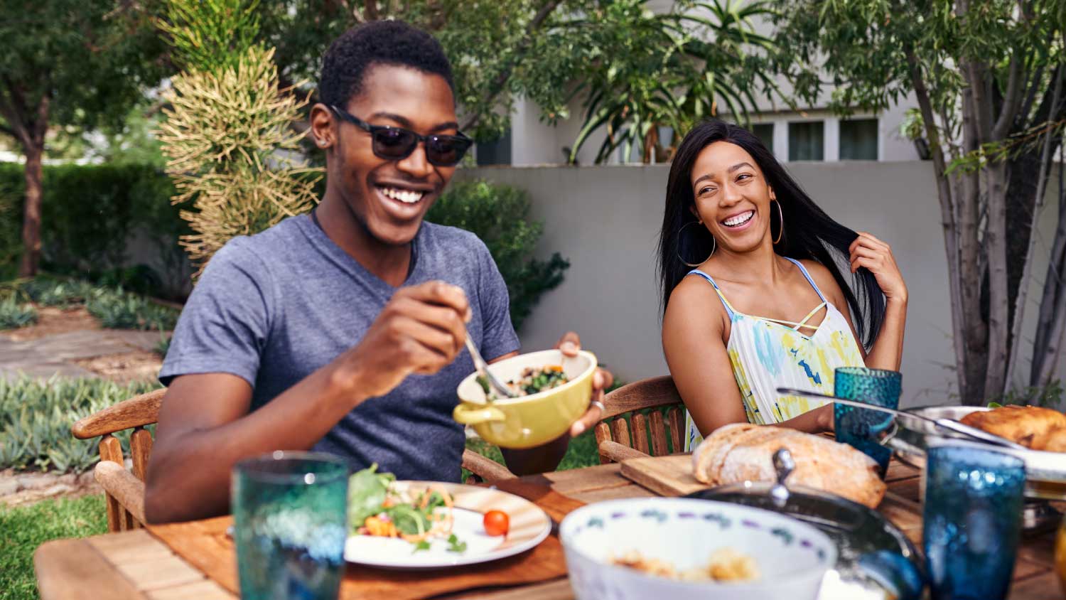 friends laughing and eating outside 