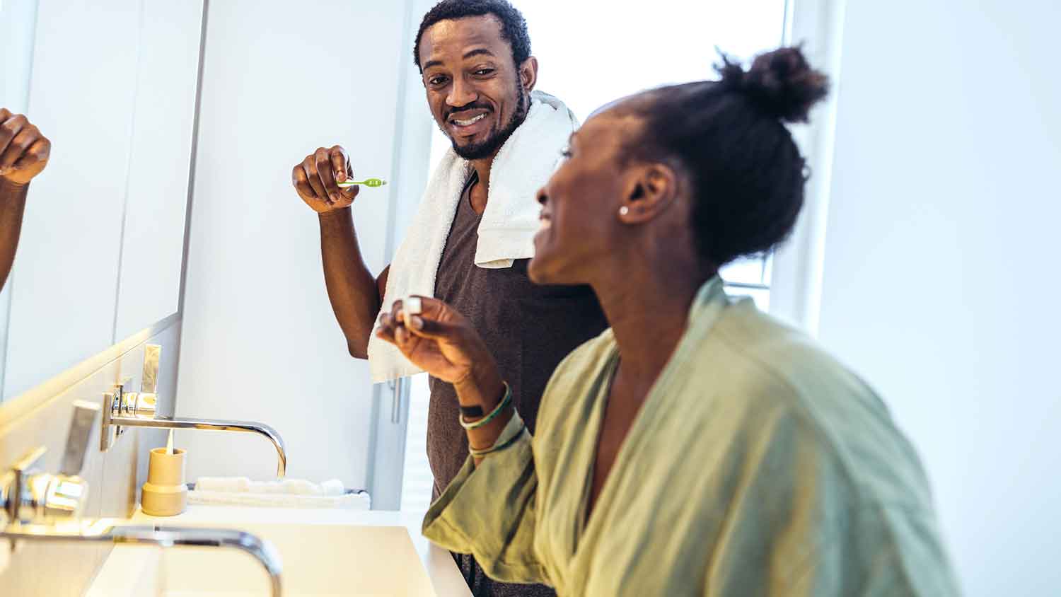 Couple in the bathroom brushing their teeth 
