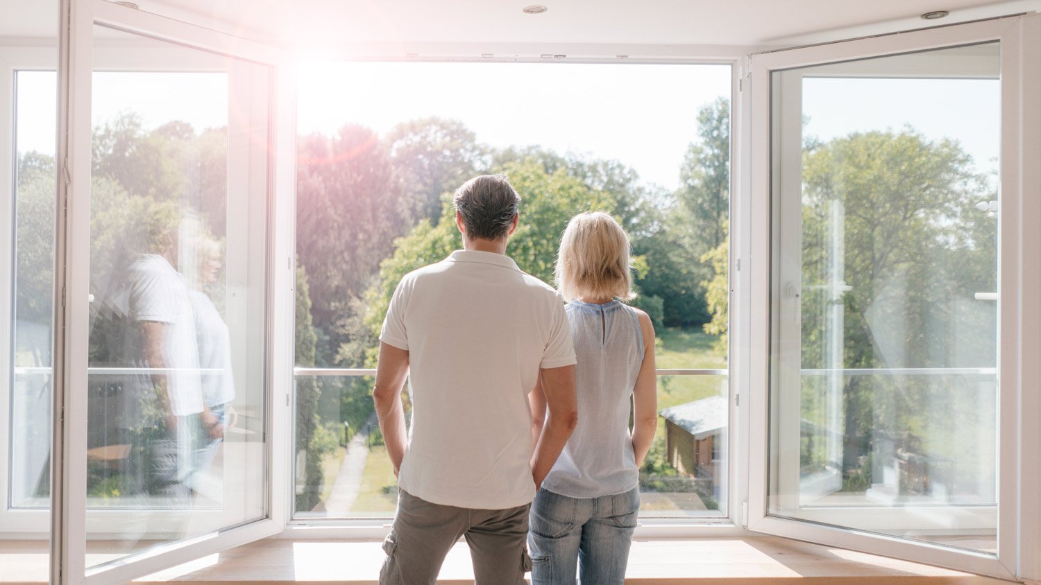 A couple looking out their window of their new home