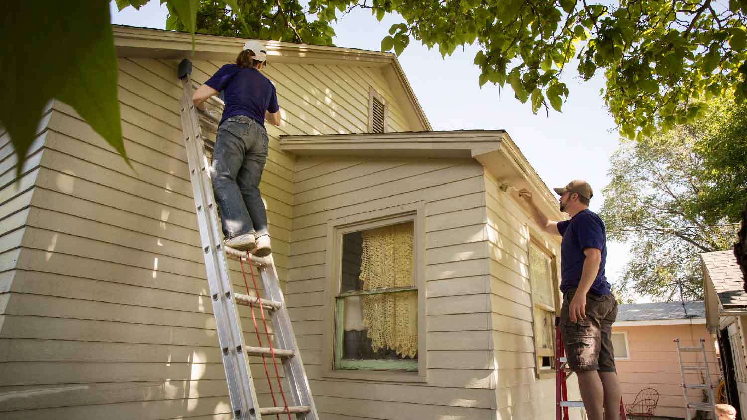 A couple painting a house