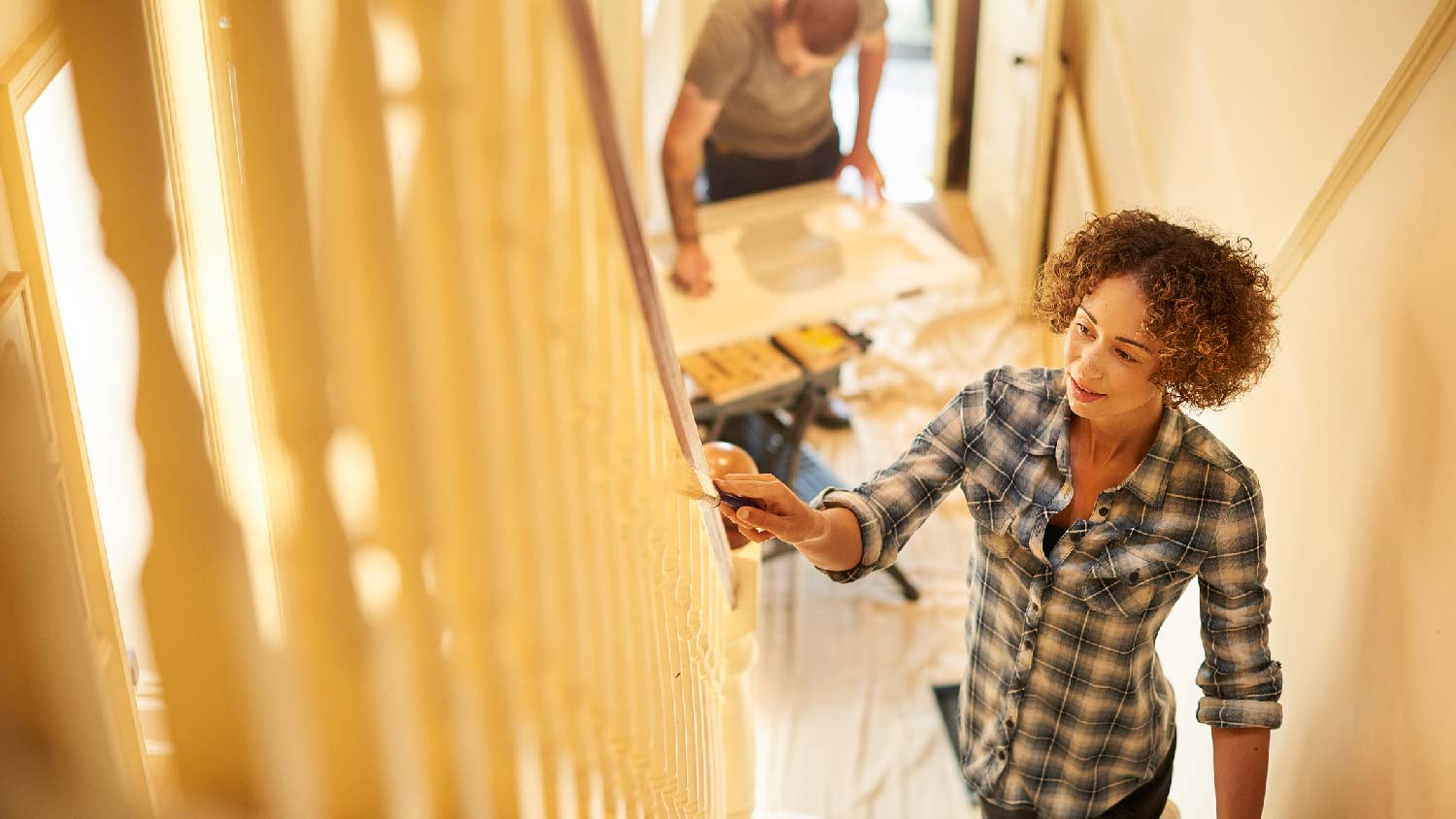 A couple painting the stairs of their house