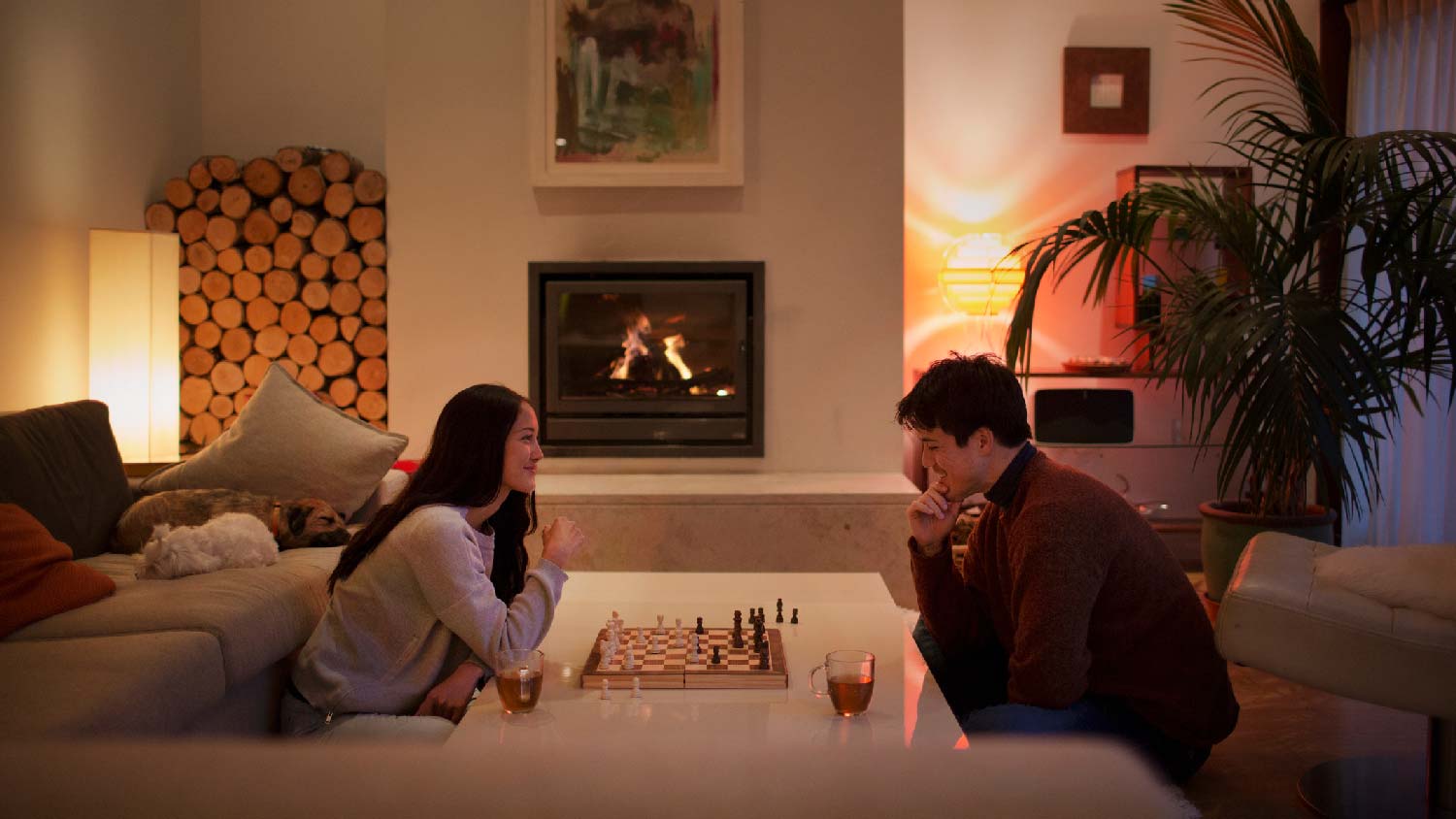 A couple playing chess in their living room with wam lighting