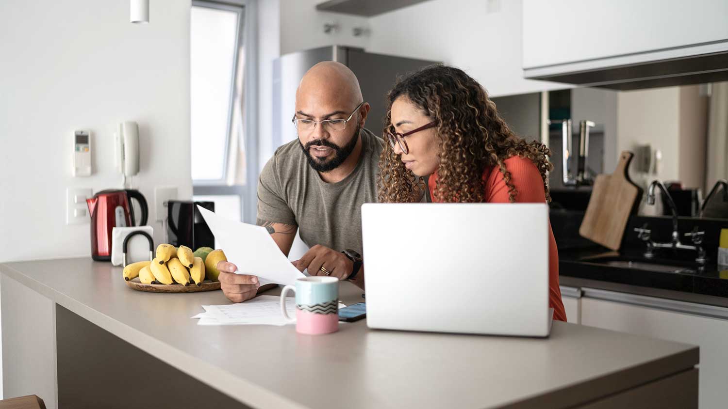 Couple at the kitchen counter reading documents