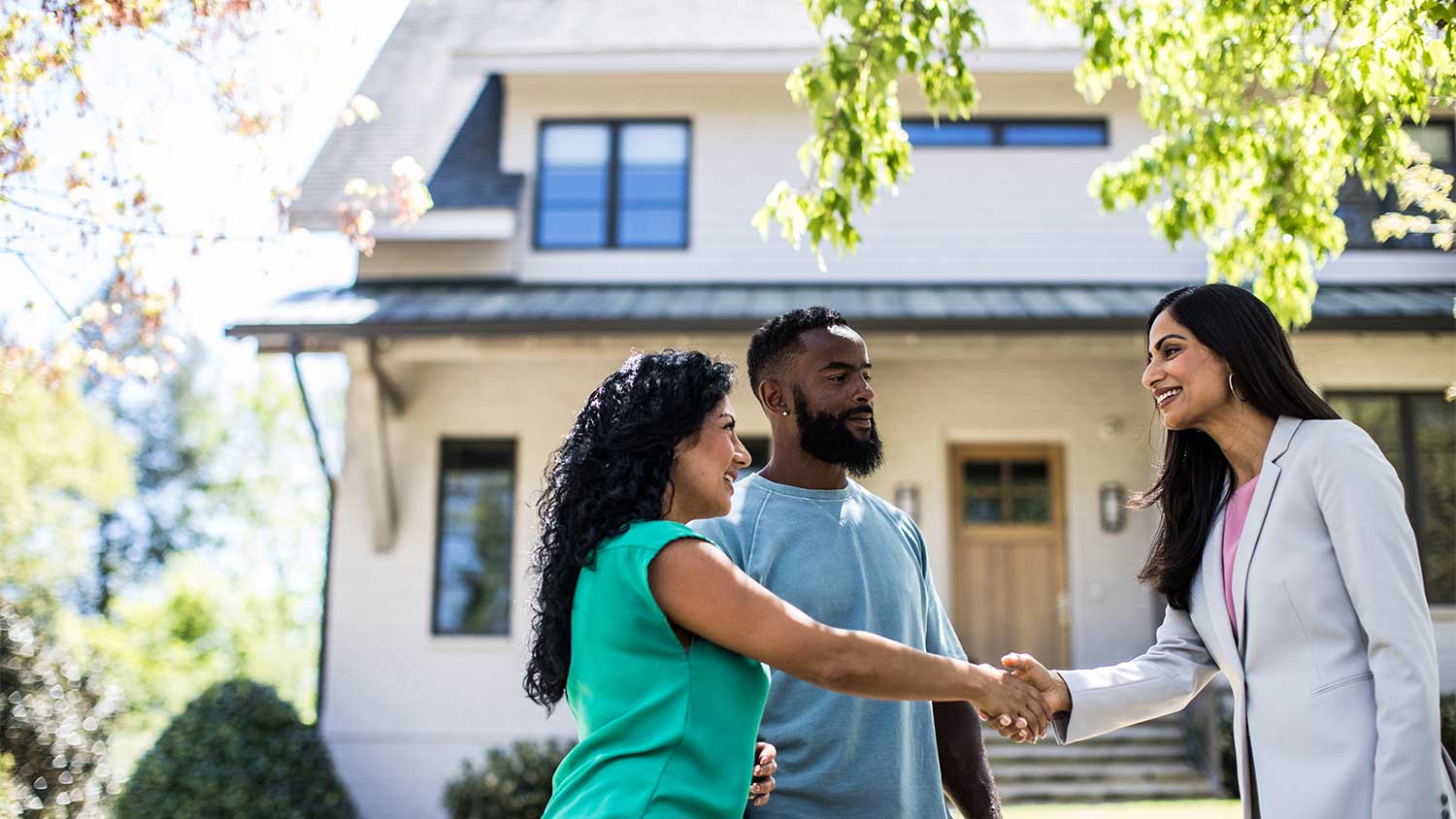 Couple shaking hands with real estate agent