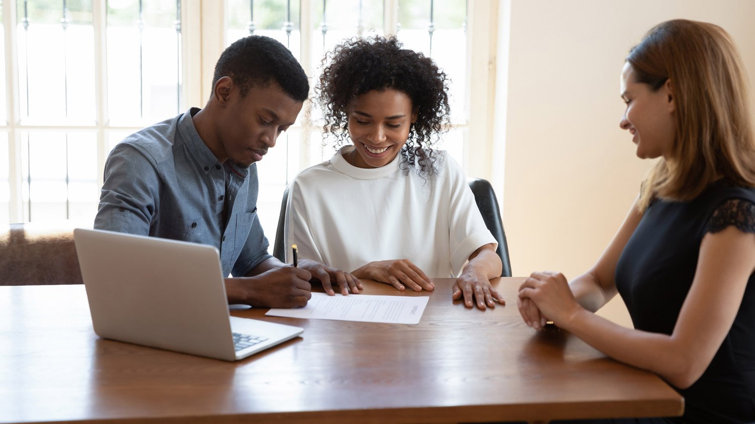 A couple signing a house contract with a property manager