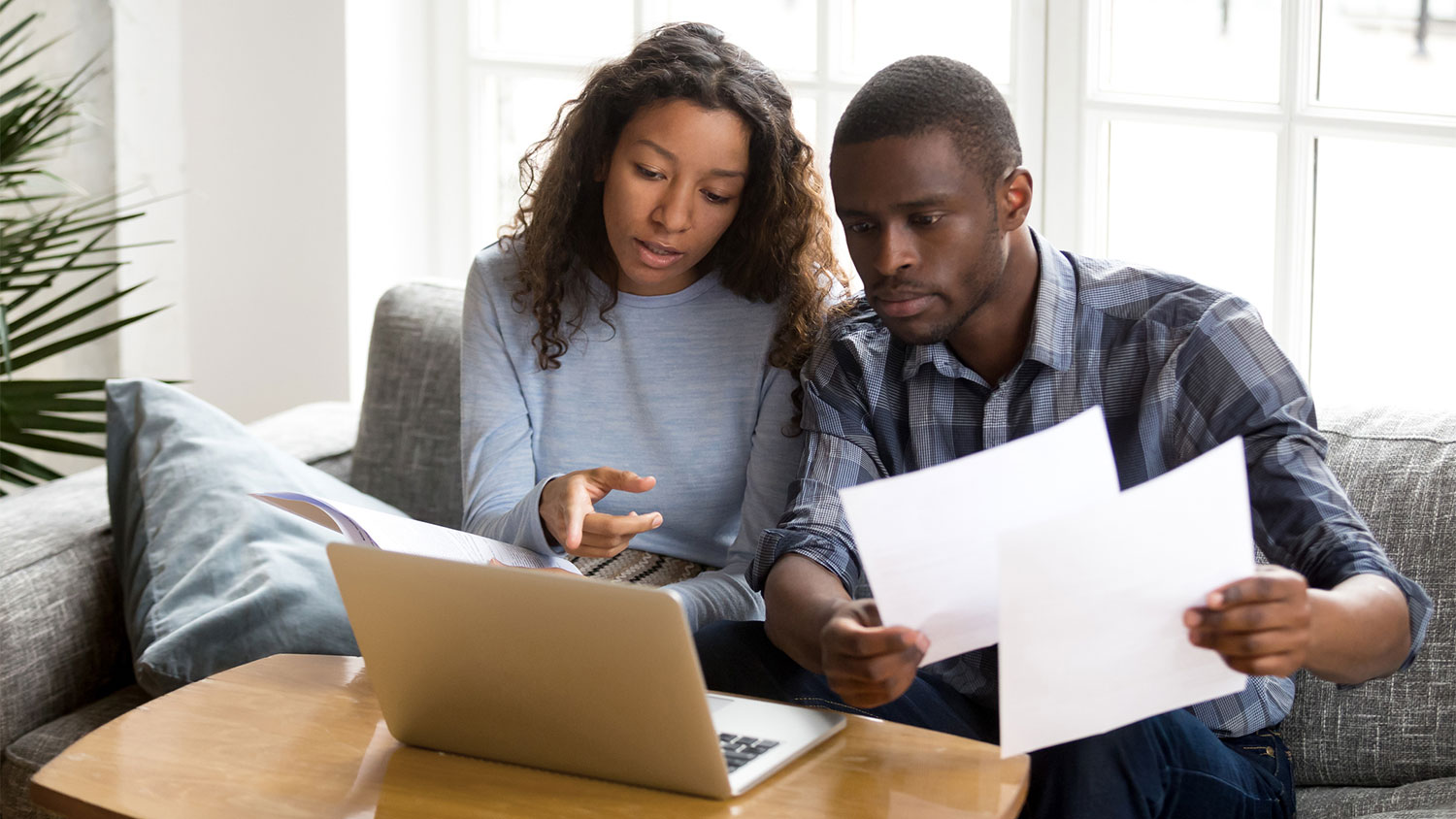 Couple in front of a laptop discussing documents