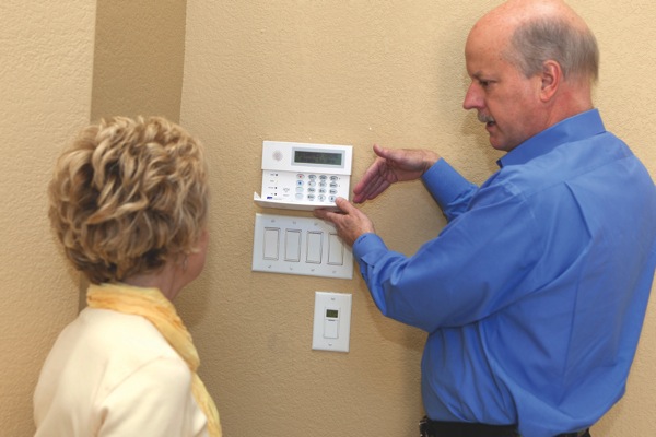 security company owner demonstrates alarm features to homeowner