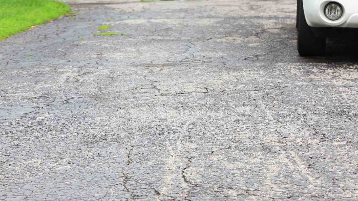 closeup of cracked asphalt driveway