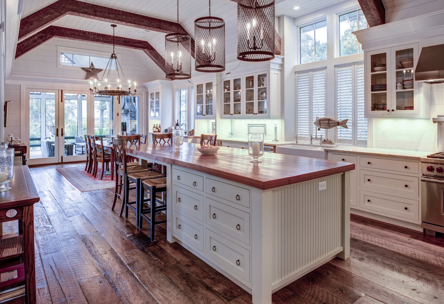 Farmhouse/craftsman kitchen and dining room with hardwood floors, exposed beams, shiplap ceiling, and big center island