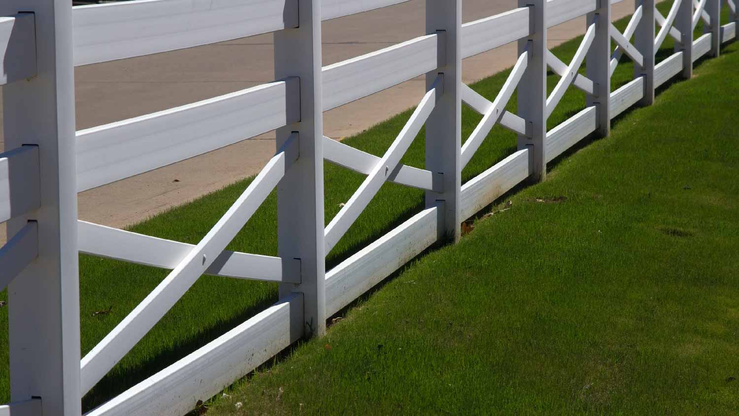 A white crossbuck vinyl fence