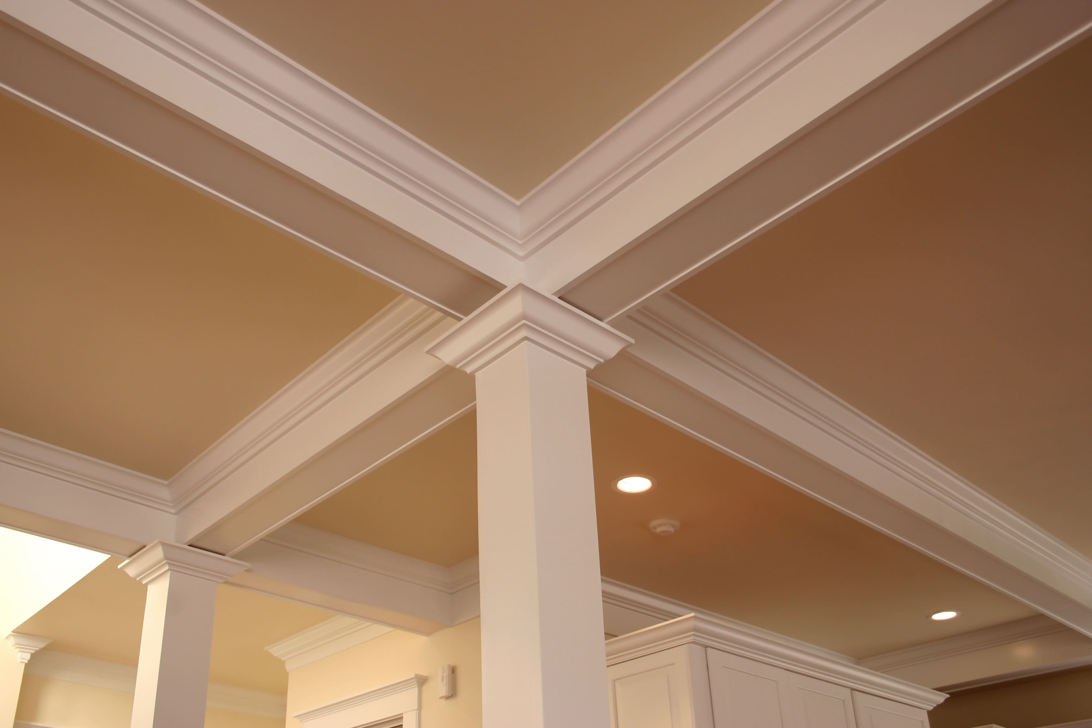 Cream colored crown molding makes a four way intersection on a ceiling