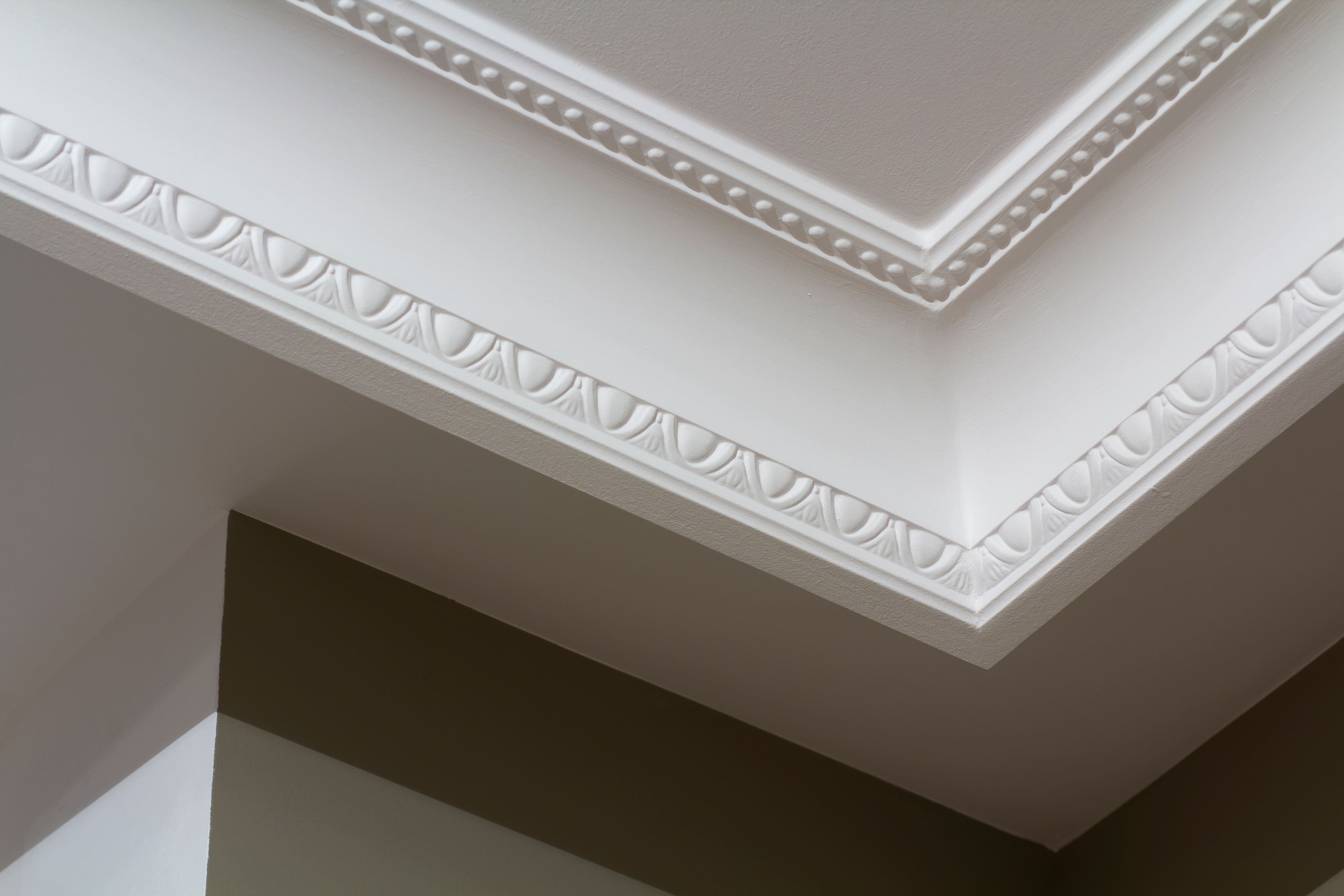 A close up of a white, intricately detailed crown molding