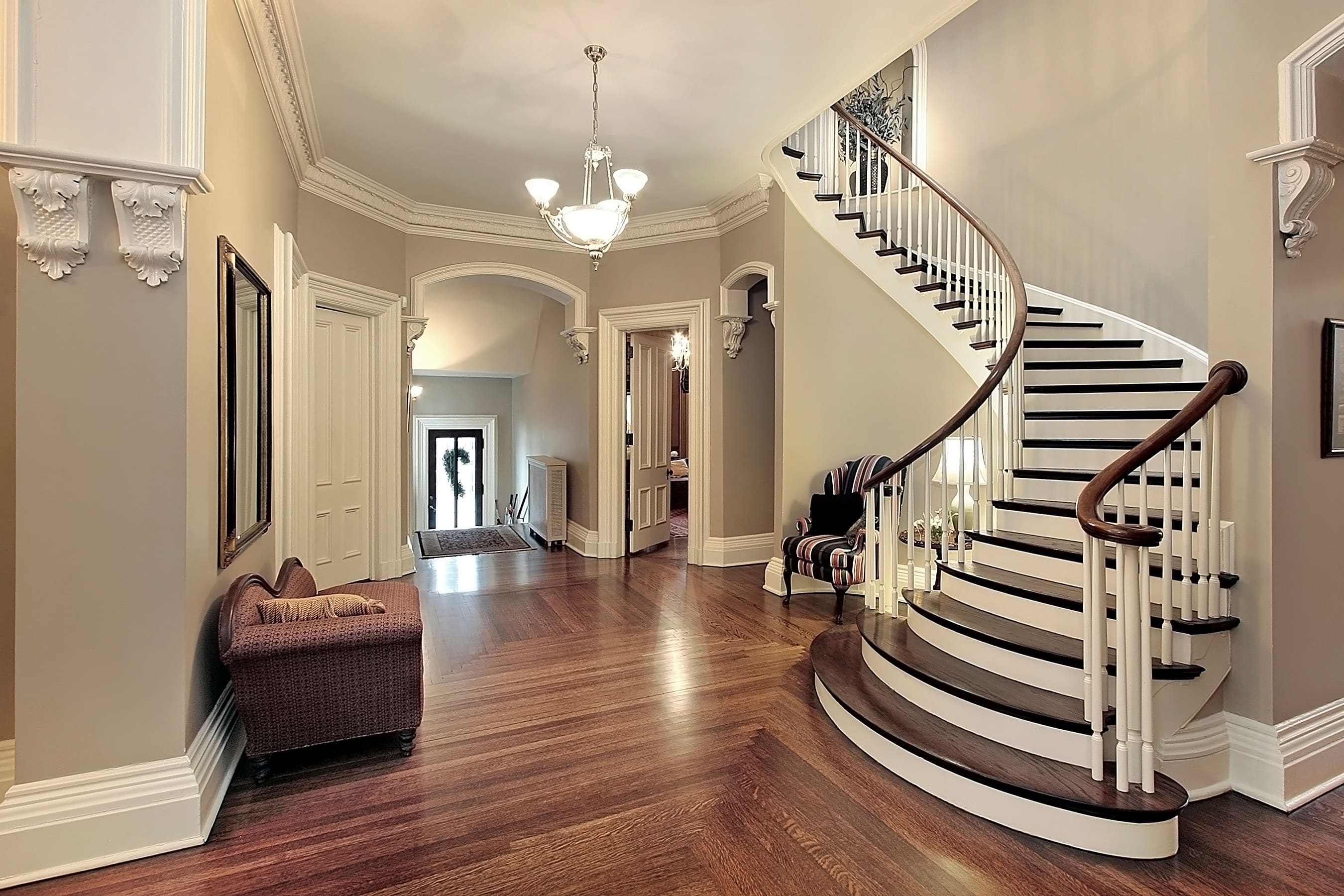 A foyer with ornate crown molding fixtures on each hallway entrance