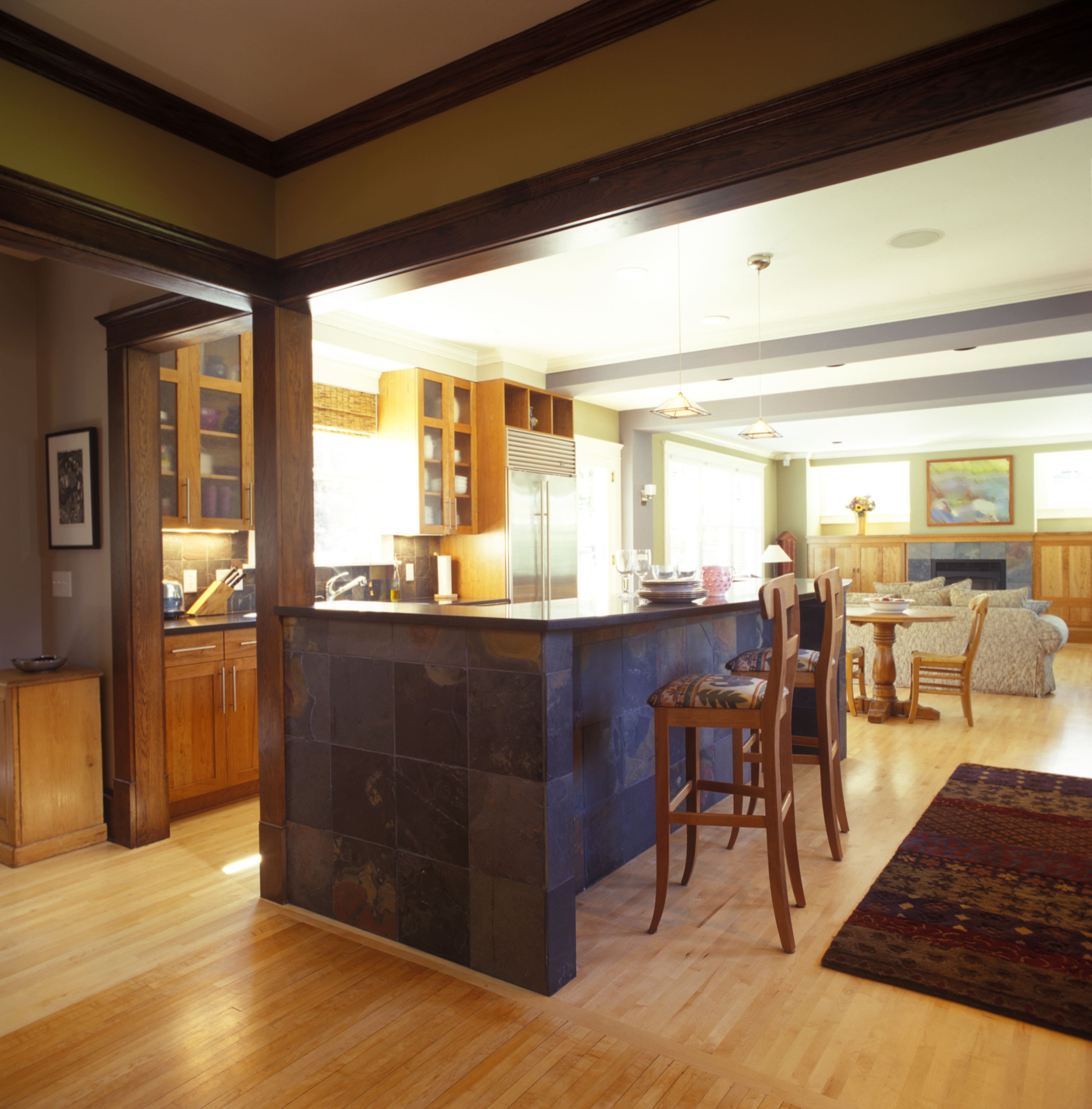 A large room with dark stained wood crown molding along the ceilings 