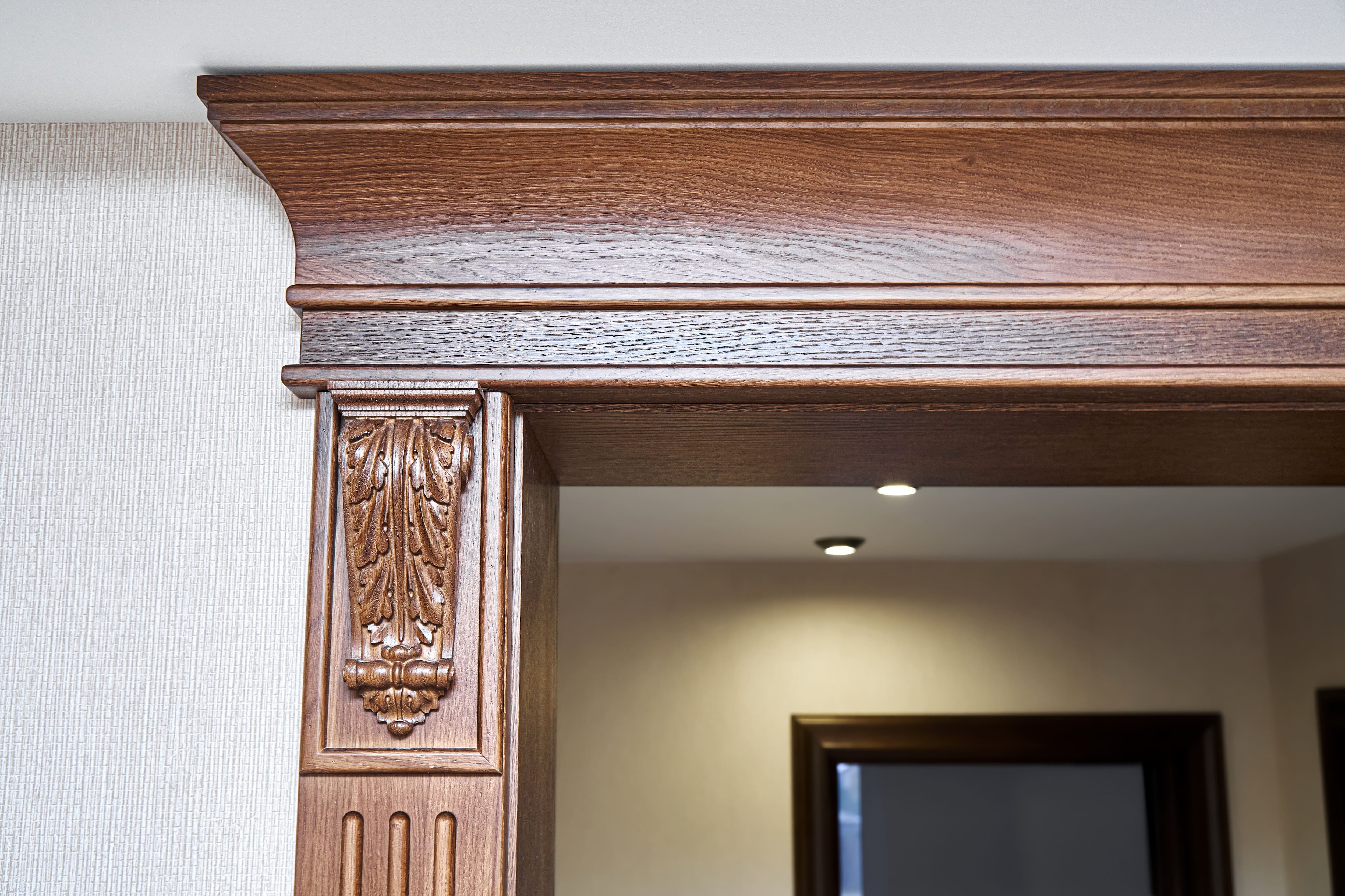 A close up of a door frame with a thick wooden crown molding around it