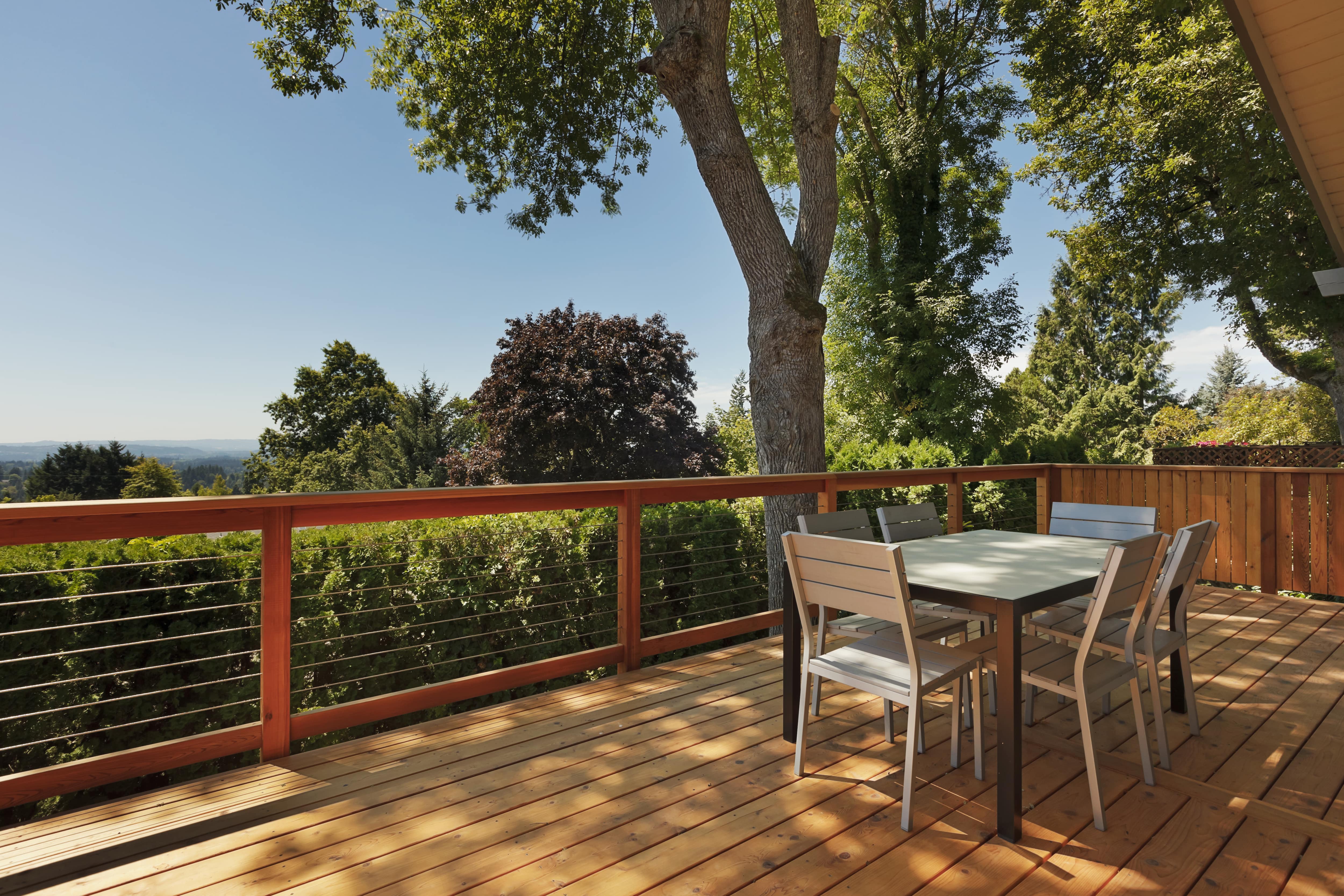 Back deck with metal cable railing overlooking the forest