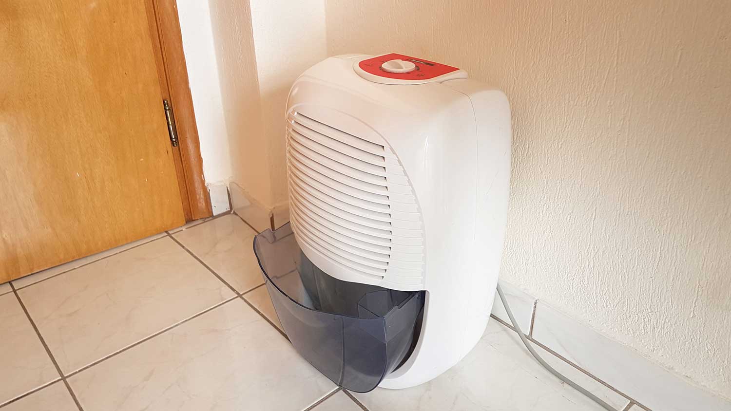 A dehumidifier sitting on a tile floor