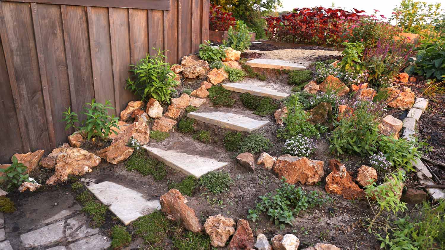Detail of a board and batten siding house next to a beautiful garden