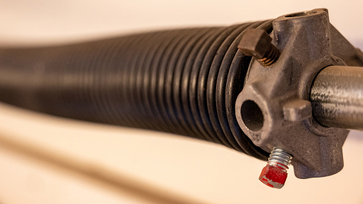 Close up side view of garage door coiled spring