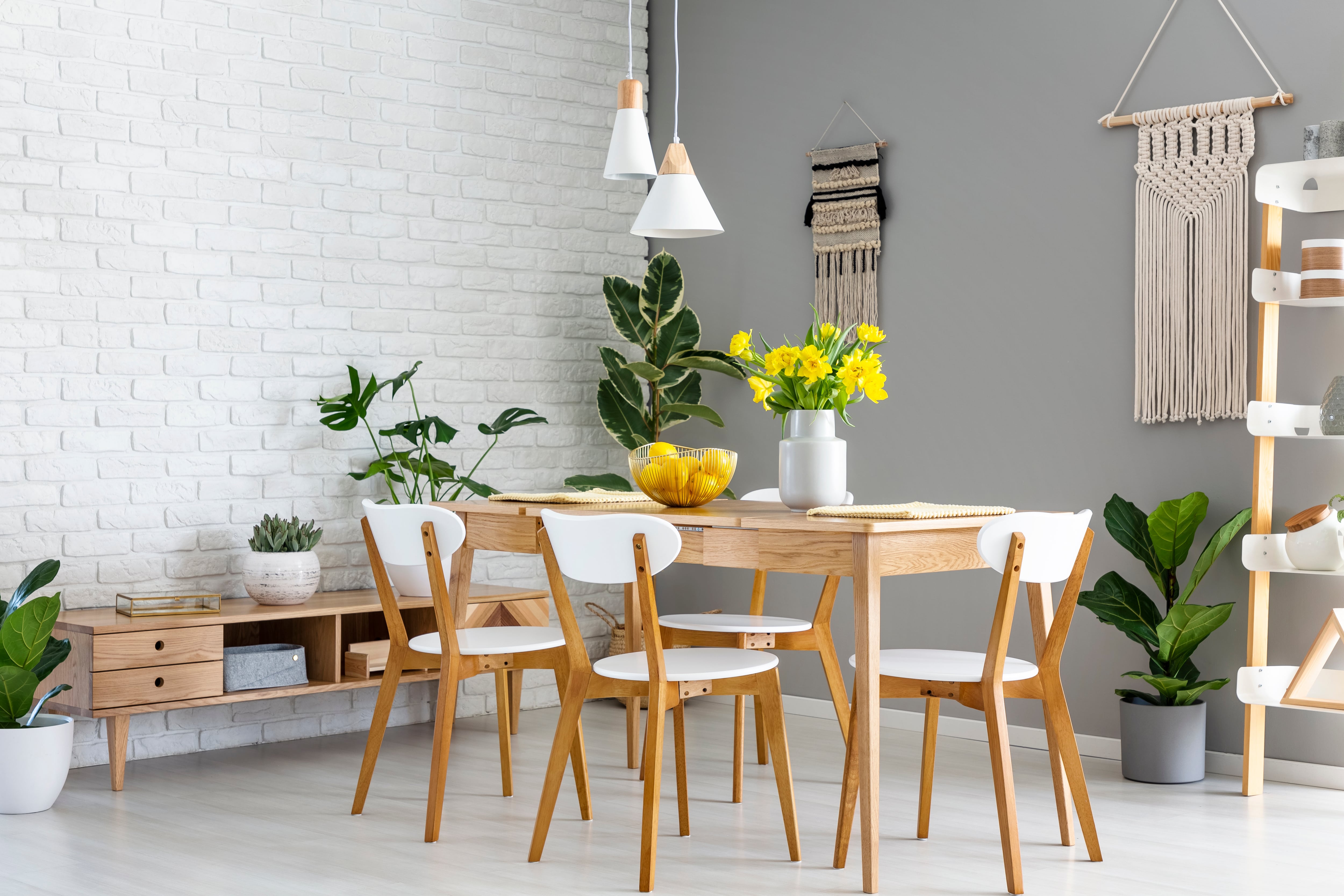 An airy light wood dining room with white accents and pendant lights