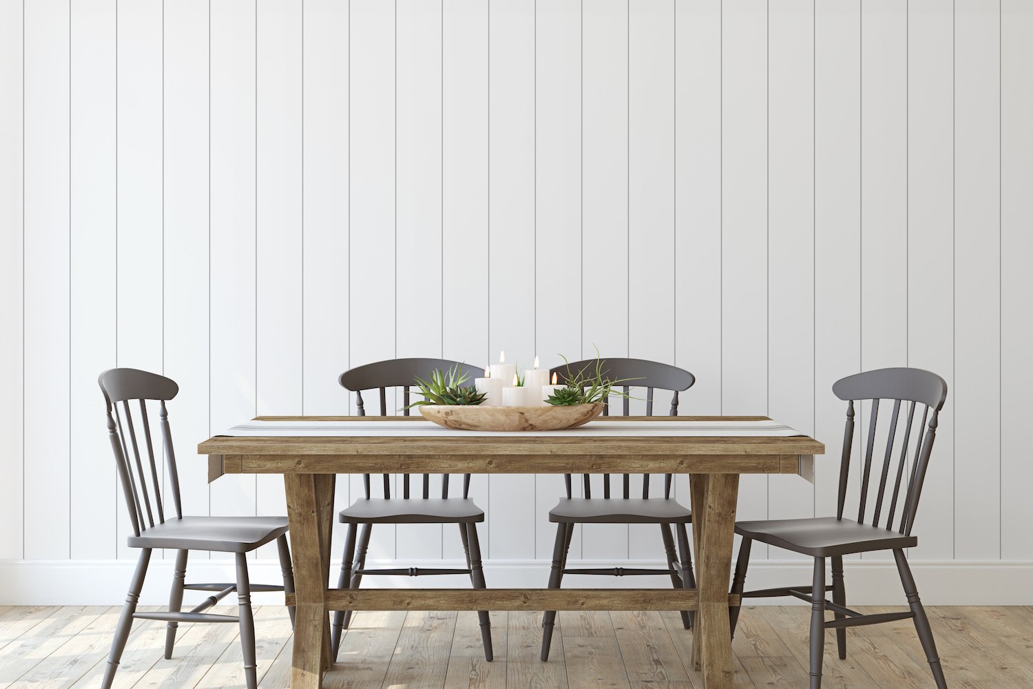 Farmhouse dining table and chairs in front of white vertical shiplap accent wall