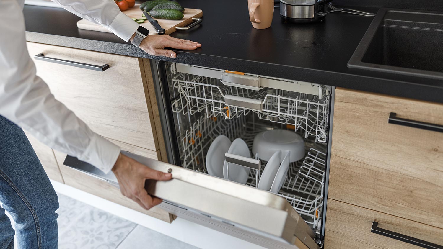 Opening dishwasher in kitchen