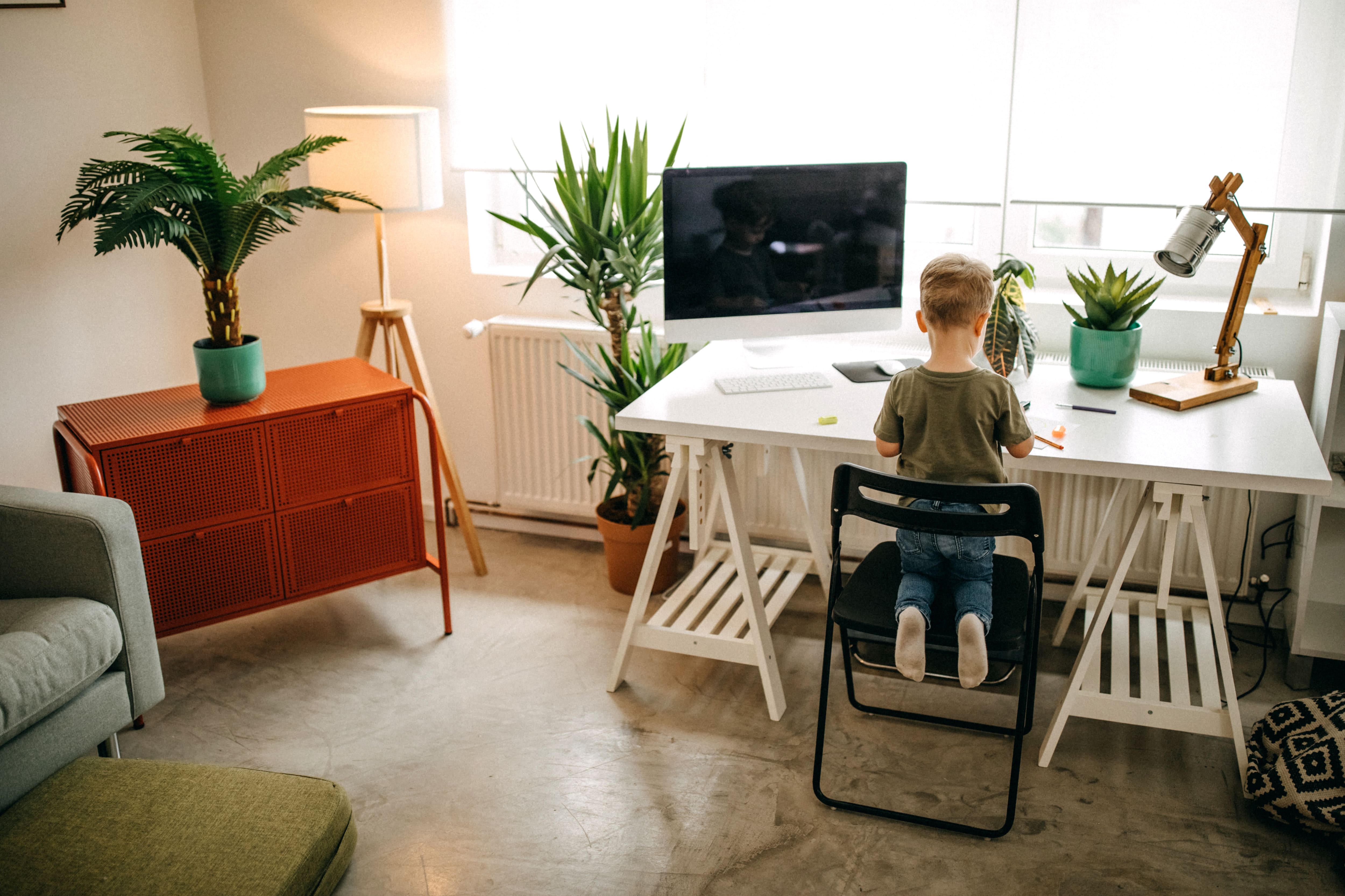 Little boy sitting at home office desk