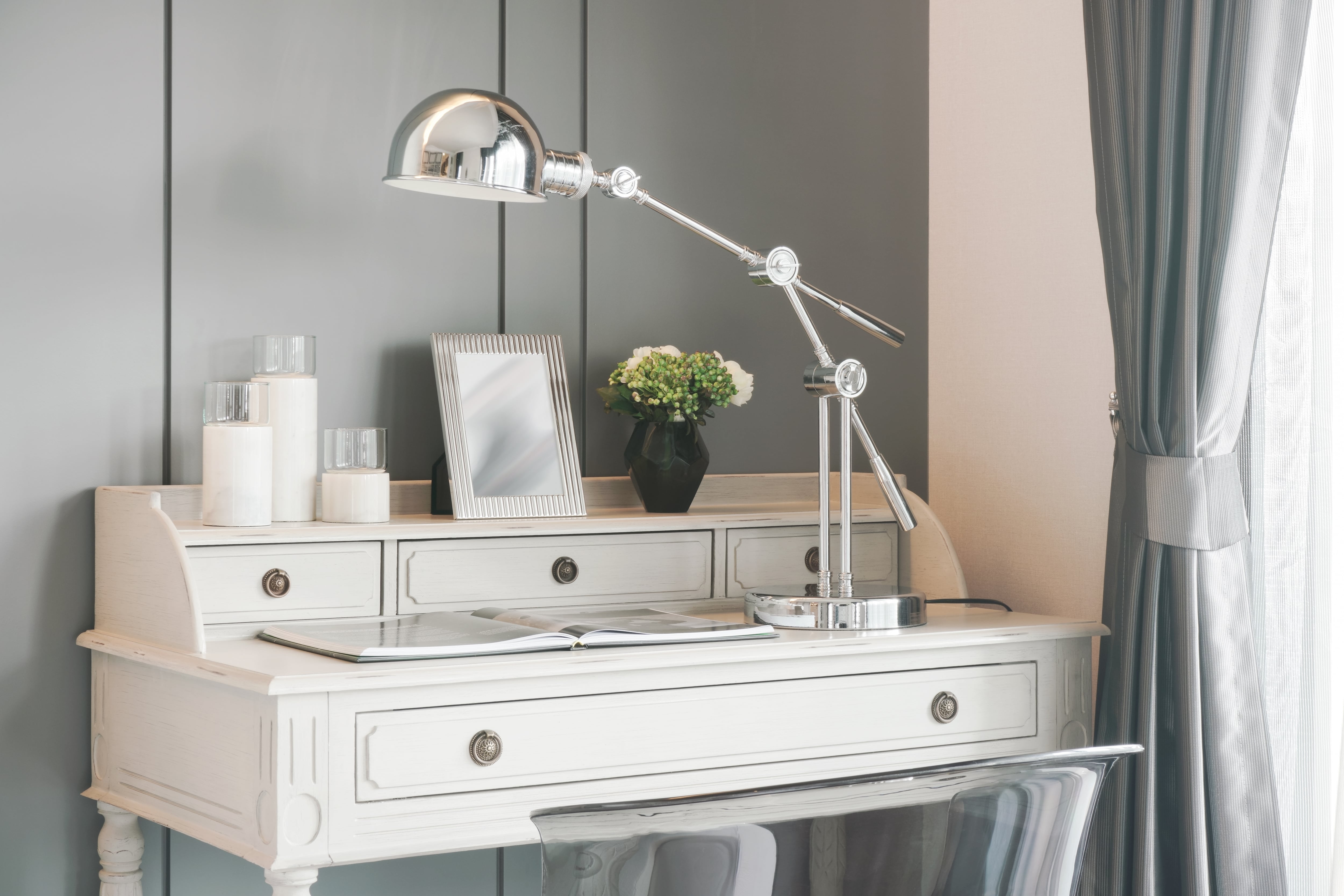 White antique piece of furniture used as an office desk