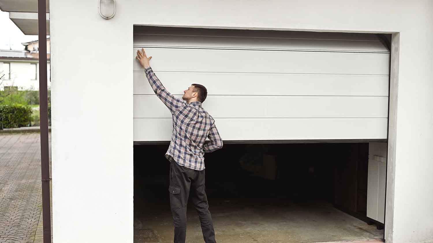 Homeowner inspecting garage door panels