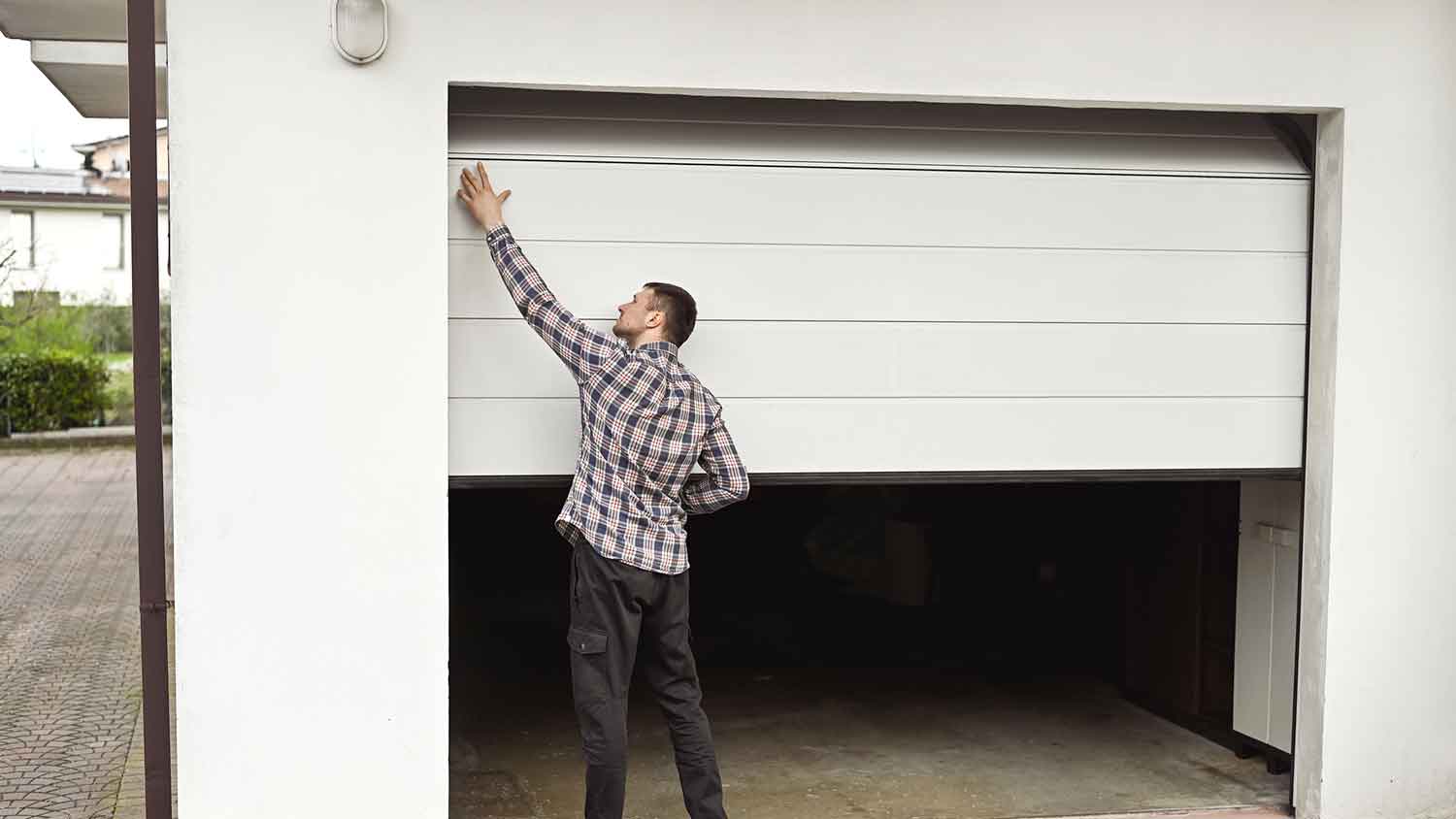 Homeowner inspecting garage door panels 