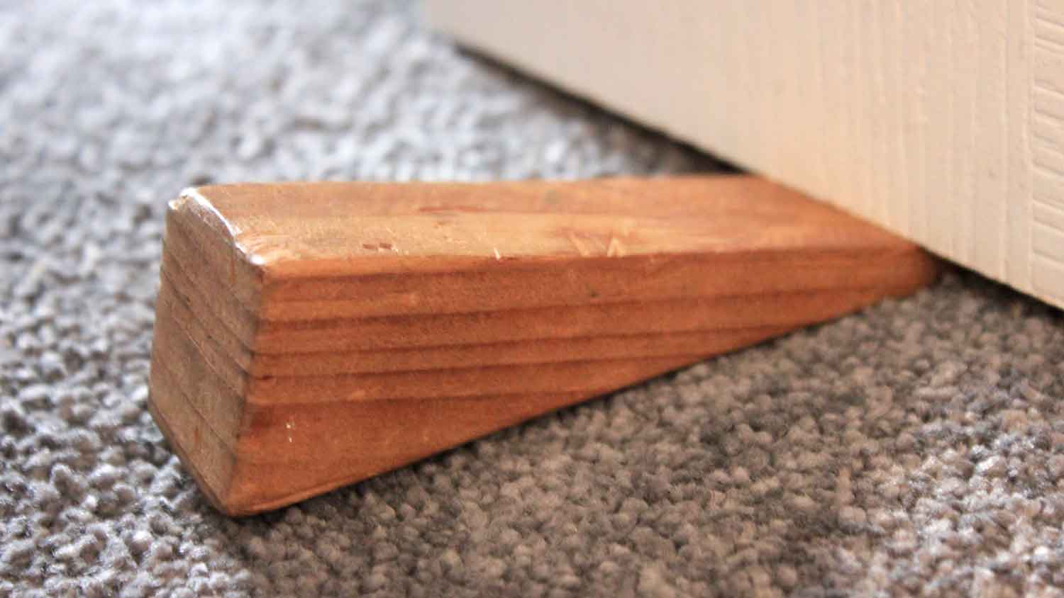 Closeup of a wooden doorstop under the door