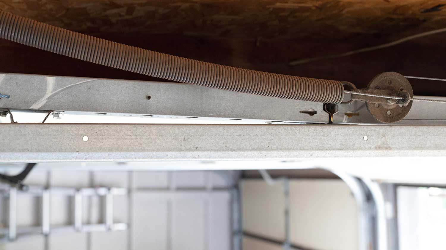 Closeup of a garage door with double-looped extension spring