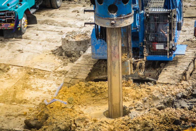 a machine drilling a hole for a home foundation