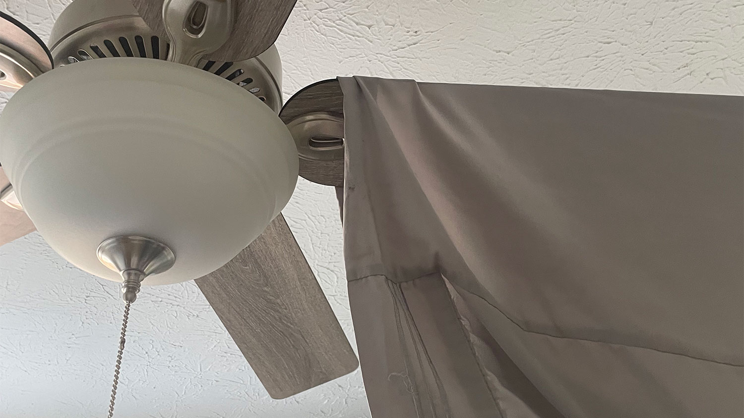 A pillowcase hands on a ceiling fan