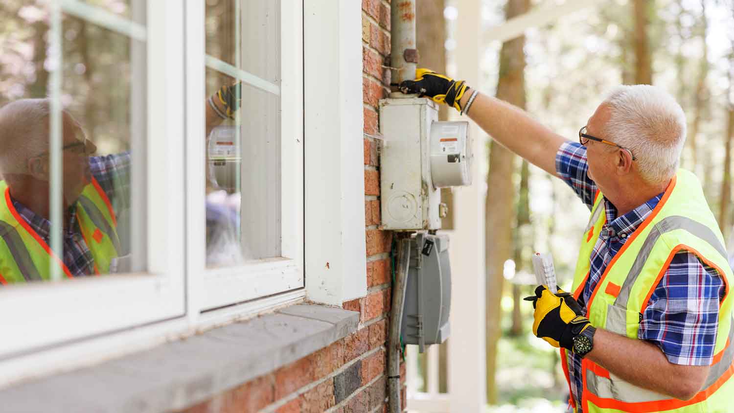 Inspector checking electrical meter outside of the house