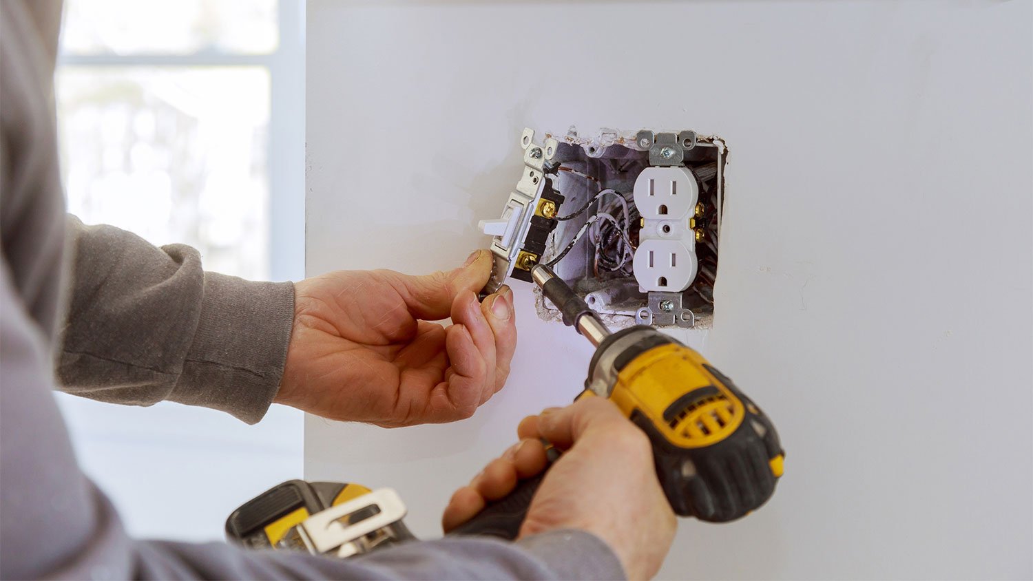 electrician installing electrical outlet