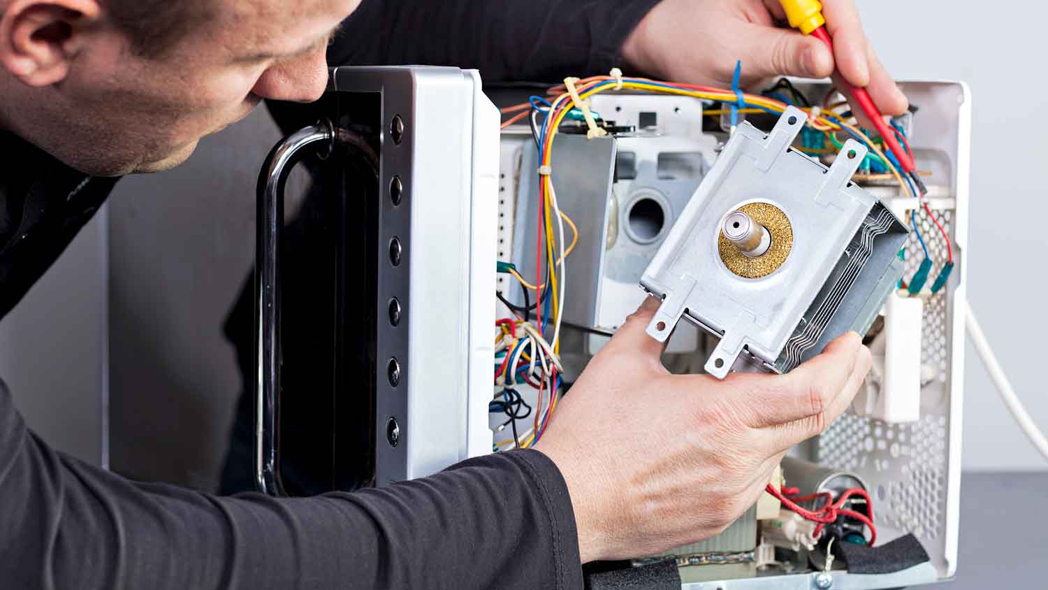 Electrician repairing microwave magnetron