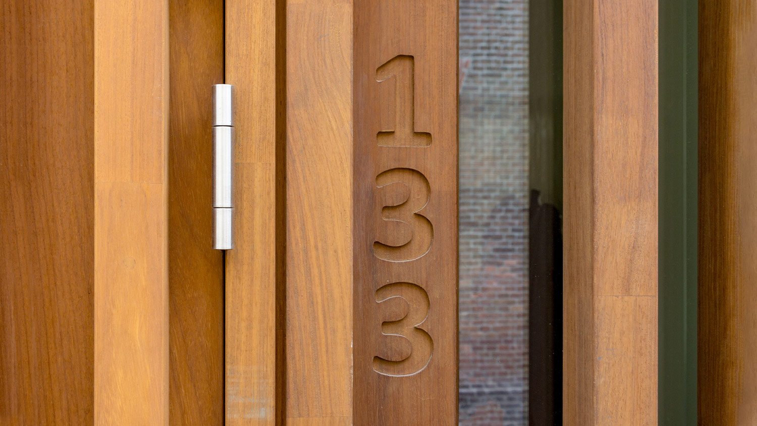 home number engraved in wood next to front door 