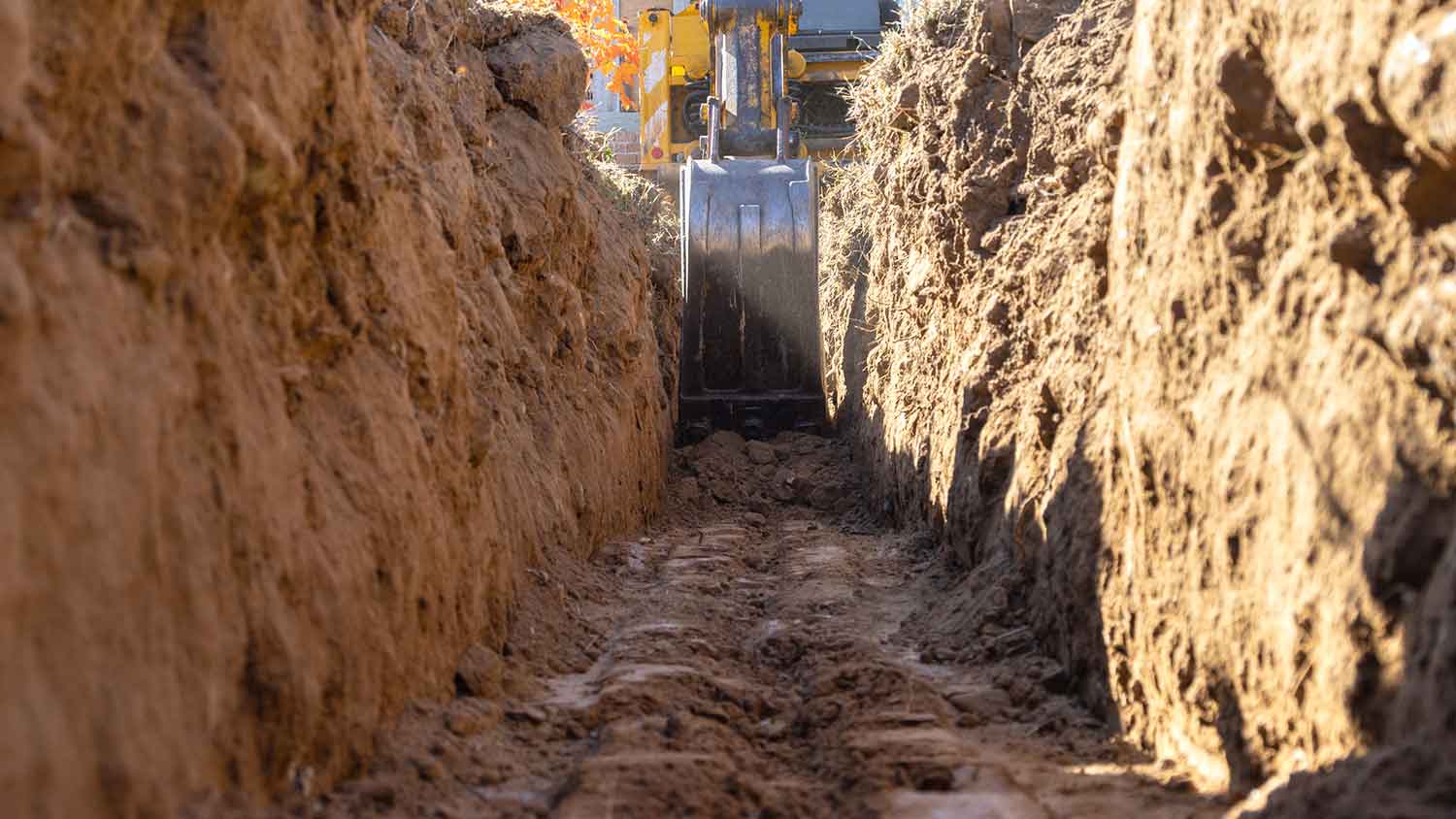 Closeup of an excavator digging a trench for house foundation