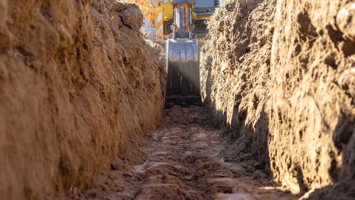 Closeup of an excavator digging a trench for house foundation 