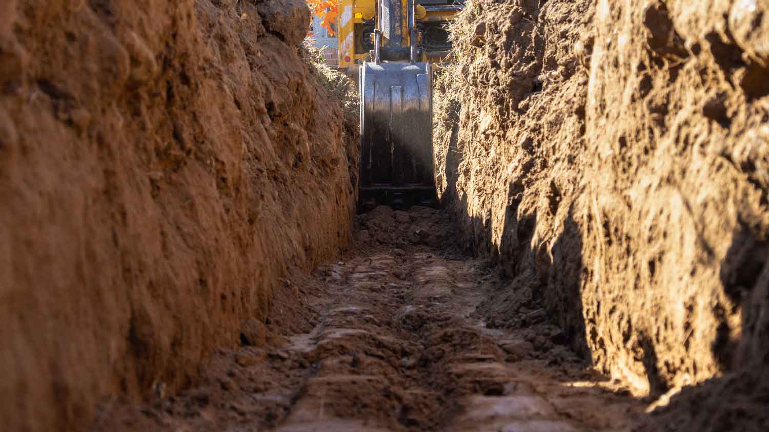 An excavator digging a drainage trench