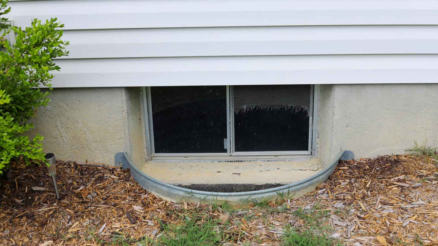 The exterior of an egress window on a house’s basement