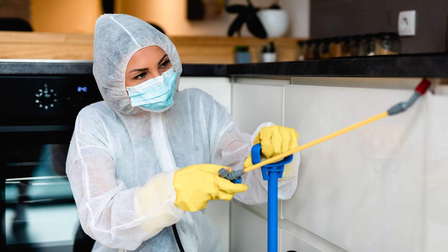 exterminator clearing out roaches in kitchen