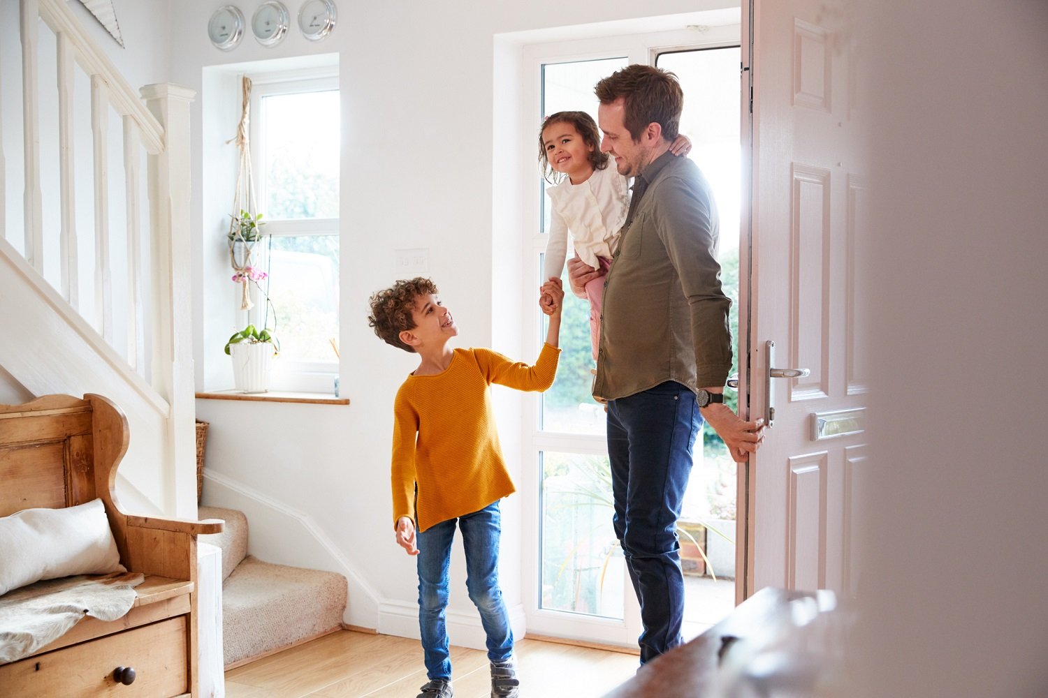 Father walks through front door with son and daughter