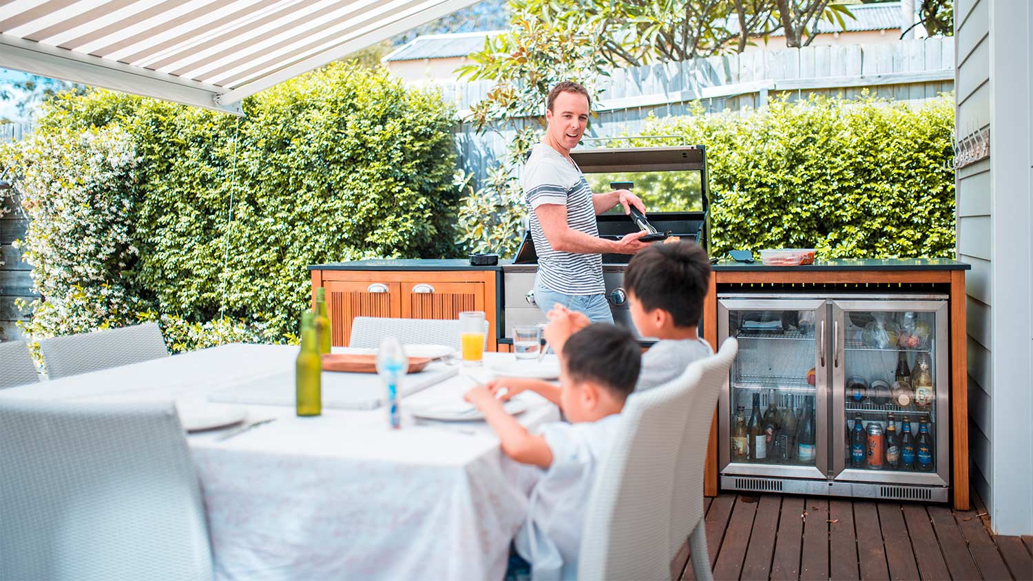 Family eating and grilling outside on the patio.